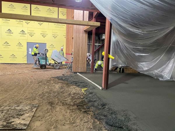 Concrete floor being poured in the lobby/entry area